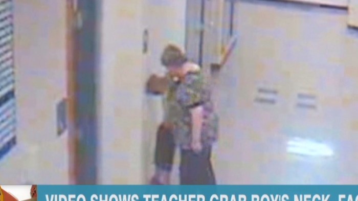 Teacher grabbing a child firmly by the arm